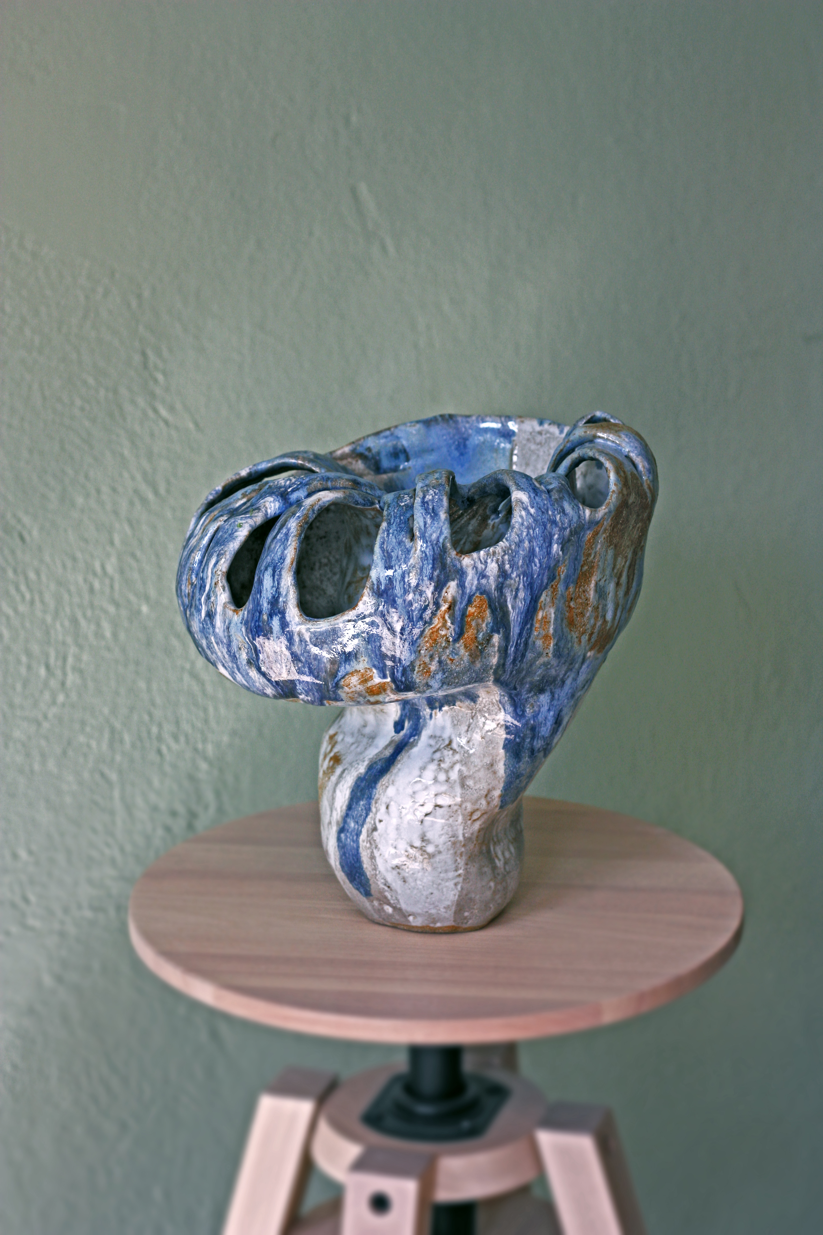 Hands carving details into a clay piece